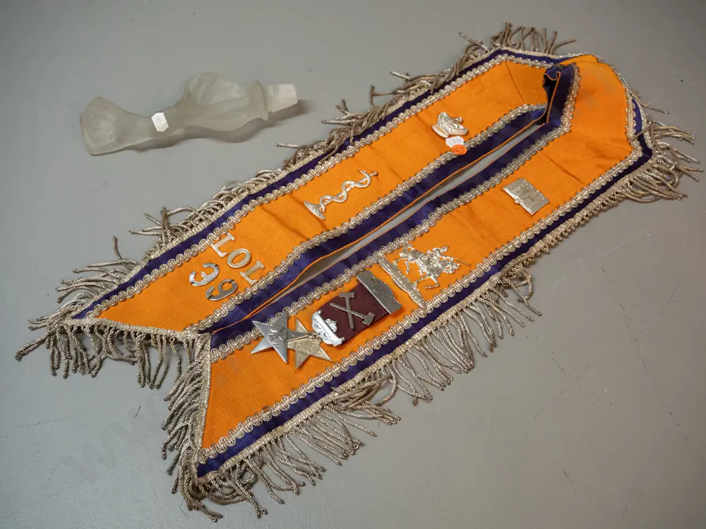 lodge sash with assorted plated metal decorations and a deco style figural frosted glass stopper, chips to stopper end. Image 1++