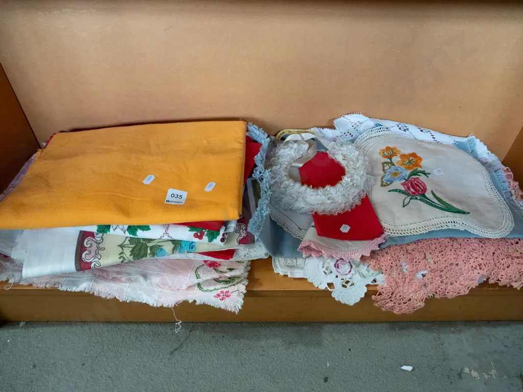 shelf of hand worked linen table cloths etc. Image 1++