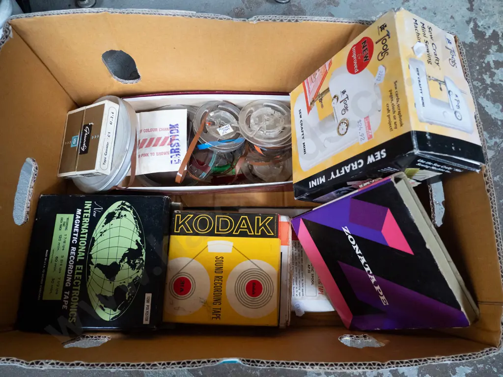 box of various 2-track tape reels and small crafter's sewing machine Image 1++