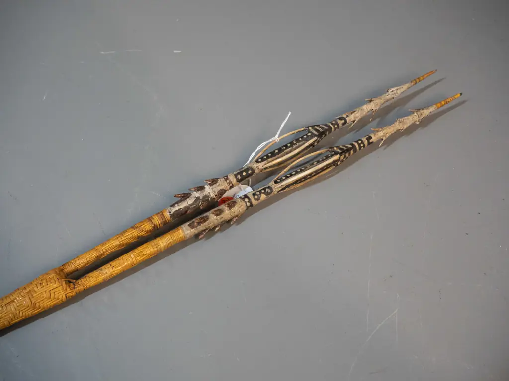 spear (Solomon Islands) with double pronged timber head, carved motifs, shaft covered with woven cane, barbs made from Image 1++