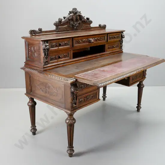 1870s European dark stained oak desk w/ carved crest and drawer fronts, pull-out top with 3 tooled