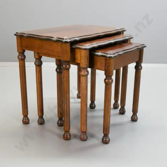 set of 3 reproduction nesting tables with shaped veneered tops on turned fluted legs - middle has staining and marks to