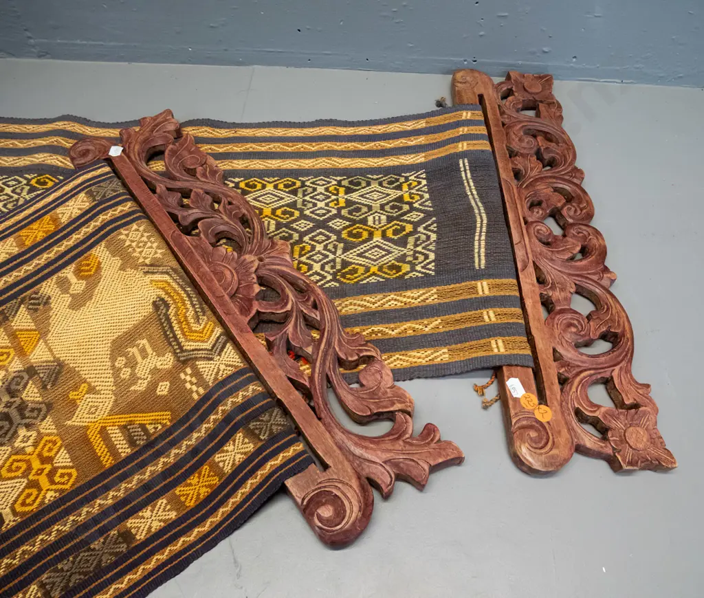 2 Indonesian (Tenun Ikat) woven fabric wall hangings on carved timber hangers - some fraying and wear, fading, one has a Image 1++