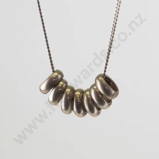 silver necklace with 7 small rings stamped 925