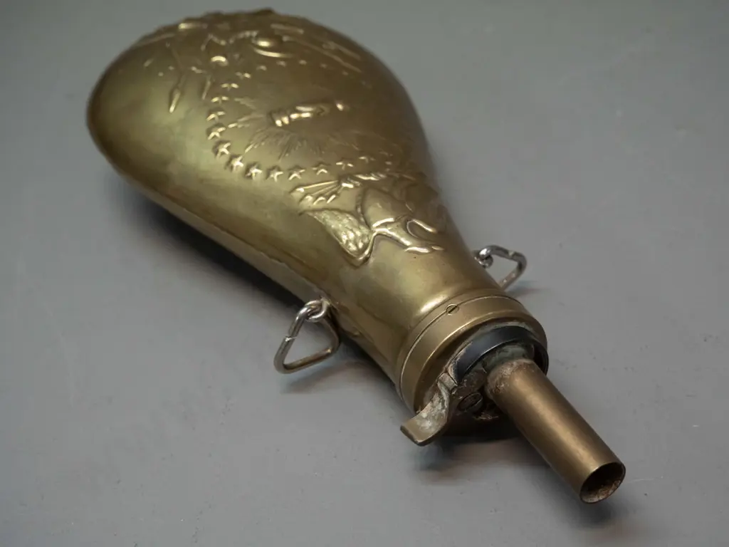 reproduction pressed brass powder flask with "US" and various insignia L-230 W-100 Image 1++