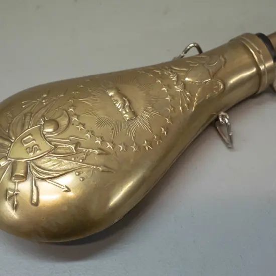 reproduction pressed brass powder flask with "US" and various insignia L-230 W-100