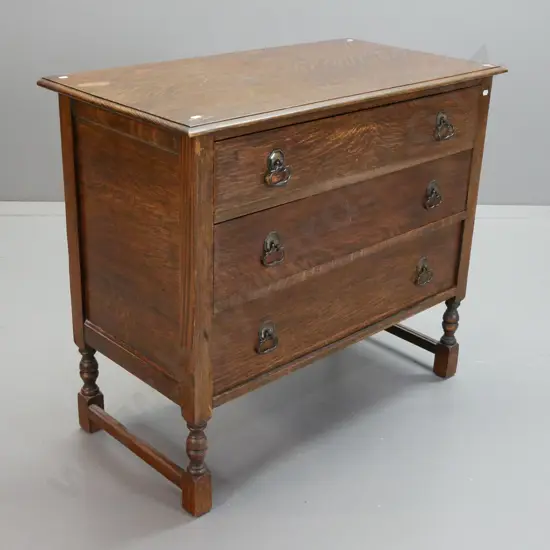 vintage oak chest of 3 drawers with metal drop handles, panelled plywood sides, stretcher base. Holes in top from