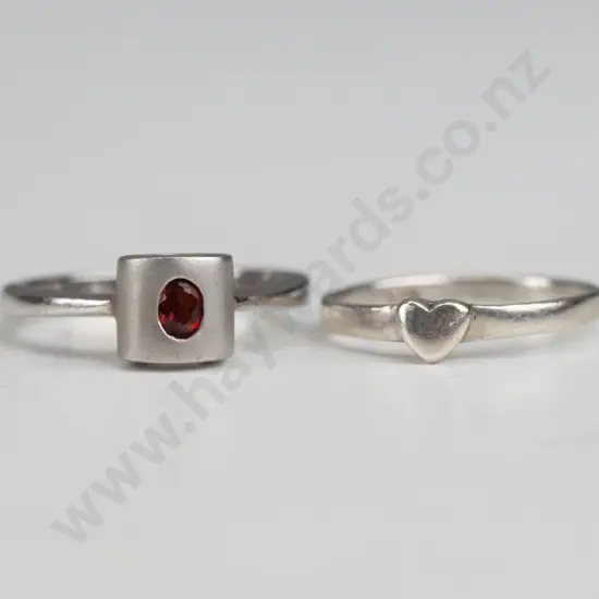 silver ring with small red stone & small silver ring with a heart, both stamped 925