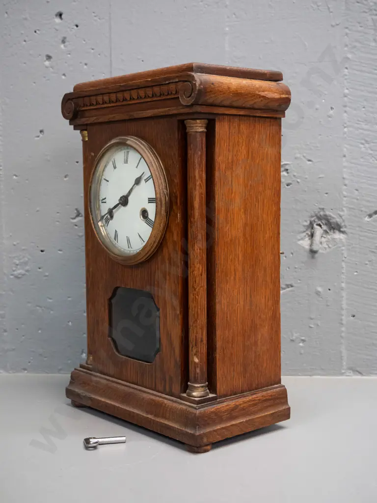 vintage oak cased chiming mantel clock with glazed door, porcelain face, brass bezel and turned columns, missing one Image 1++