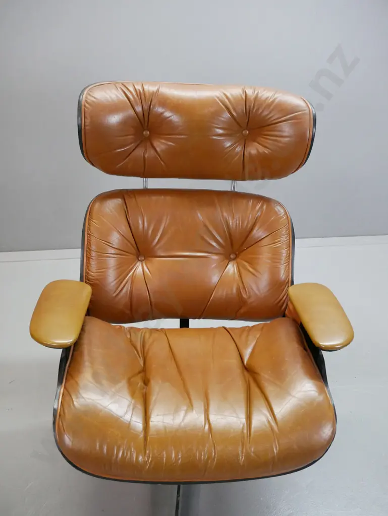 vintage Eames style leather upholstered swivel lounge chair with matching footstool, vinyl upholstered arms. Missing Image 1++