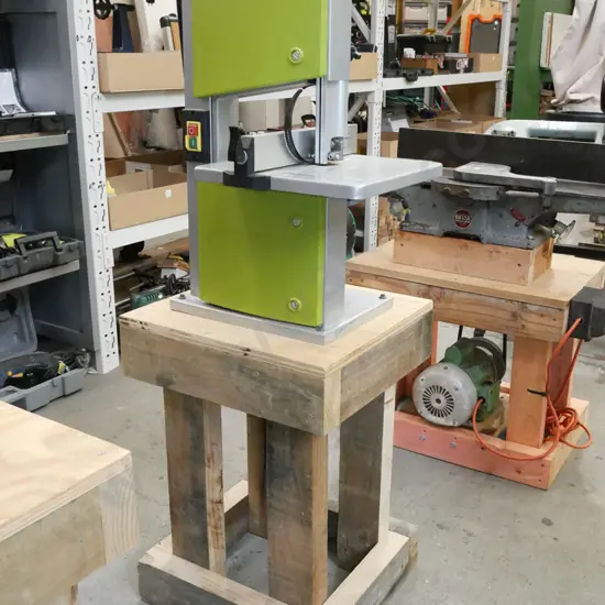 unbranded band saw on wooden stand