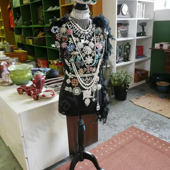 mannequin torso on stand - decorated with feather boa and numerous costume brooches and tiara