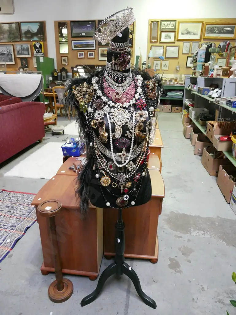 black fabric upholstered torso on stand with numerous pieces of costume jewellery Image 1++