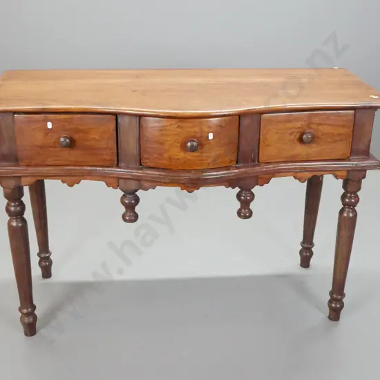 Asian teak serpentine fronted side or hall table with 3 drawers w/turned knobs, turned drop finials, on turned legs -