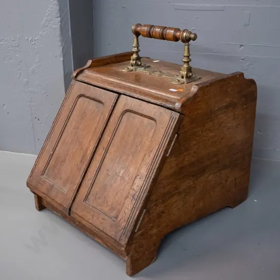 vintage oak coal scuttle with brass door-opening mechanism connected to brass and timber top handle, with tin liner.