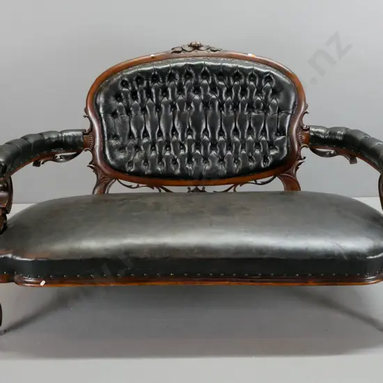 Victorian cameo-backed settee w/ black buttoned & pleated back, buttoned arms, studded seat, carved arms and back, on