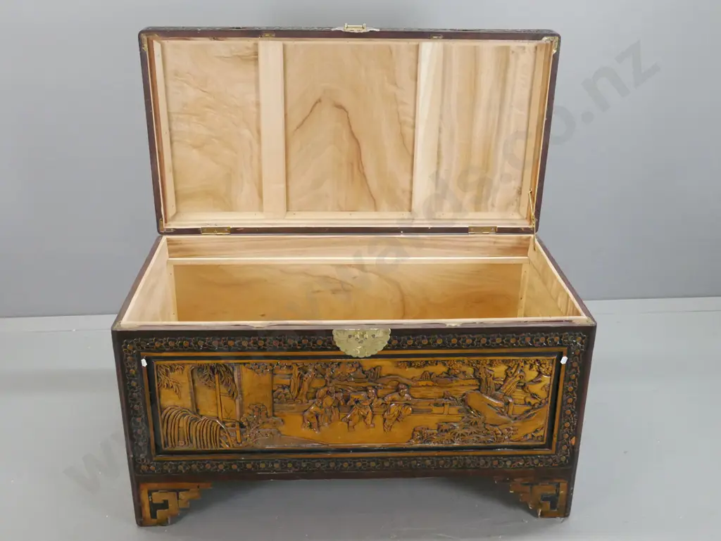 vintage carved camphorwood chest with scenic panels on top and front, floral carved edges, cut-out handles, on stepped Image 1++