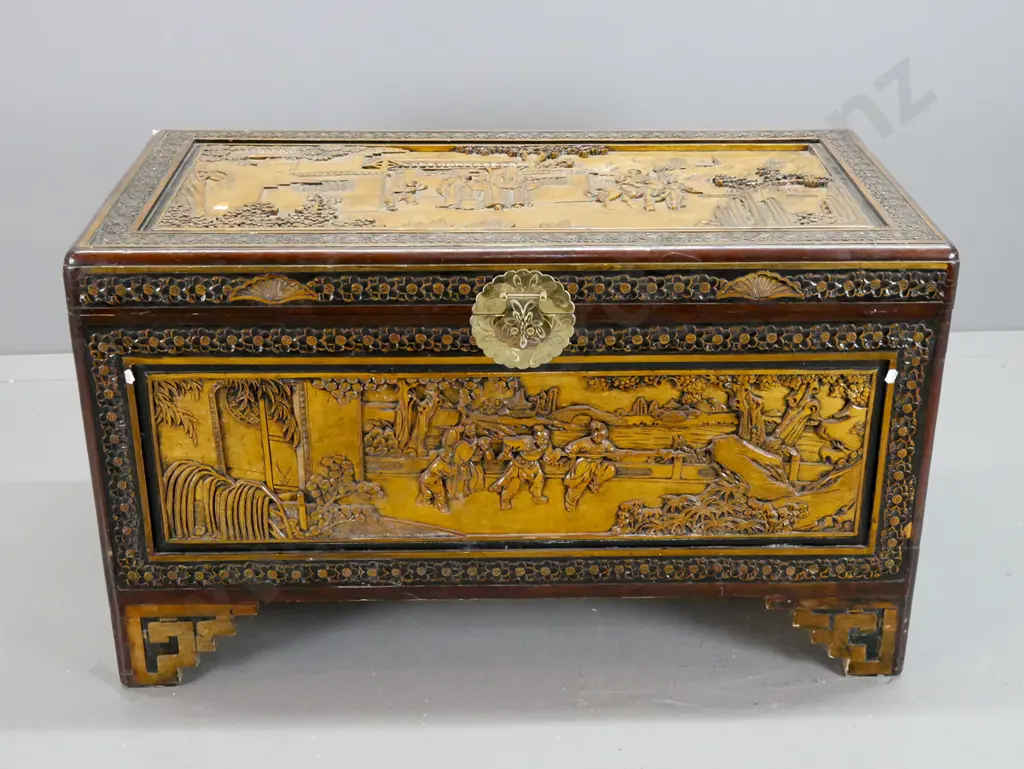 vintage carved camphorwood chest with scenic panels on top and front, floral carved edges, cut-out handles, on stepped Image 1++