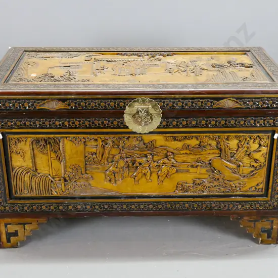 vintage carved camphorwood chest with scenic panels on top and front, floral carved edges, cut-out handles, on stepped