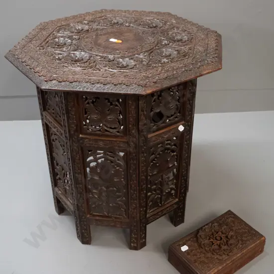 intricately carved and pierced Asian hardwood collapsible table with octagonal top, hinged stand, with similar carved
