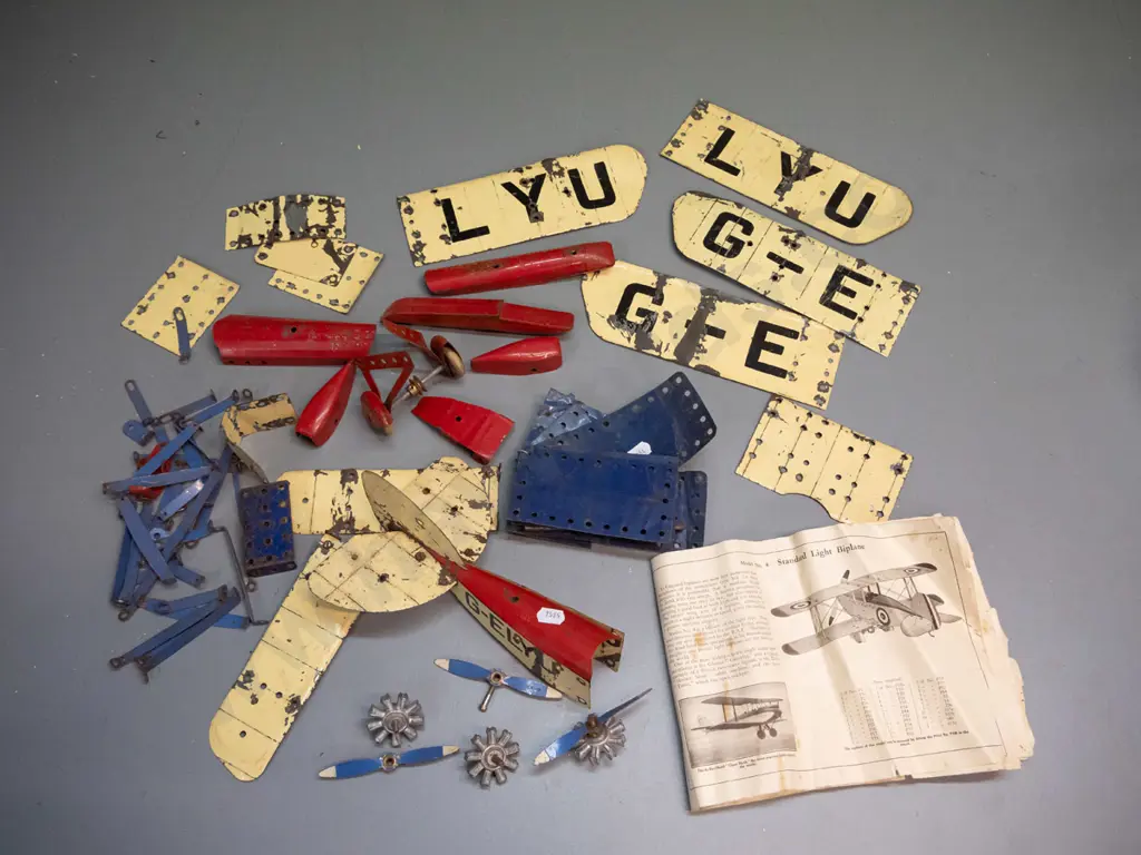vintage metal Meccano aeroplane construction kit pieces - assorted wings, wheels, and body parts, booklet missing covers Image 1++