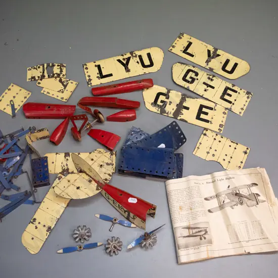 vintage metal Meccano aeroplane construction kit pieces - assorted wings, wheels, and body parts, booklet missing covers