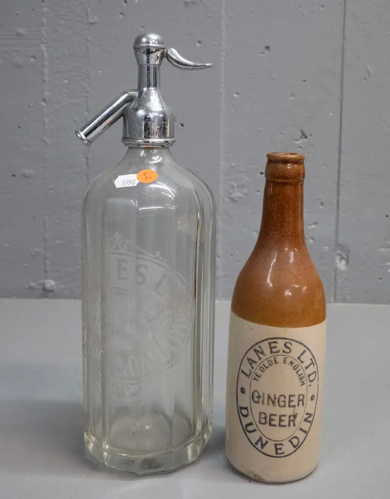 2 Lane's Dunedin items - salt-glazed ginger beer bottle and a soda syphon with chrome top marked Lane's H-300 D-100 Image 1++