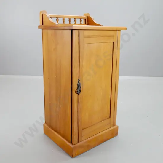 vintage rimu bedside cabinet with shaped gallery and turned spindles, panelled door with metal drop handle, one shelf,