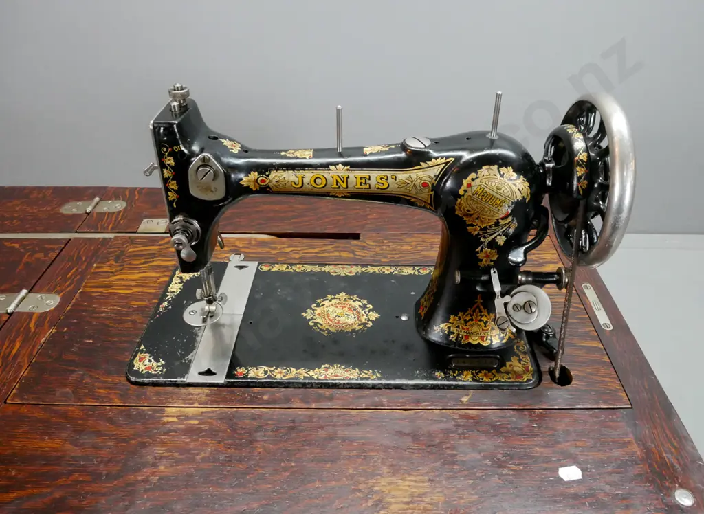 vintage Jones treadle sewing machine in figured oak cabinet with fold-out top linked to lift mechanism, 2 doors Image 1++
