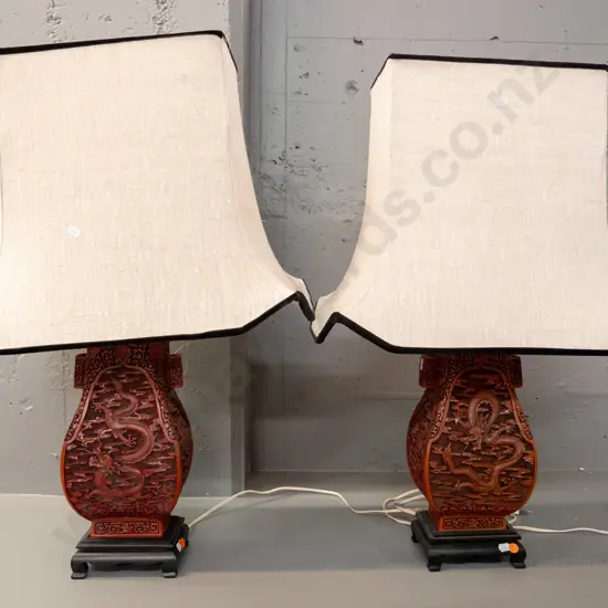 pair of composite Chinese cinnabar style dragon pattern table lamps on painted wood bases with rectangle shaped linen