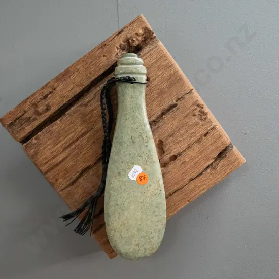 wall hanging carved green stone mere with braided cord, hanging on rustic timber piece - mere is L240, overall H290 W300