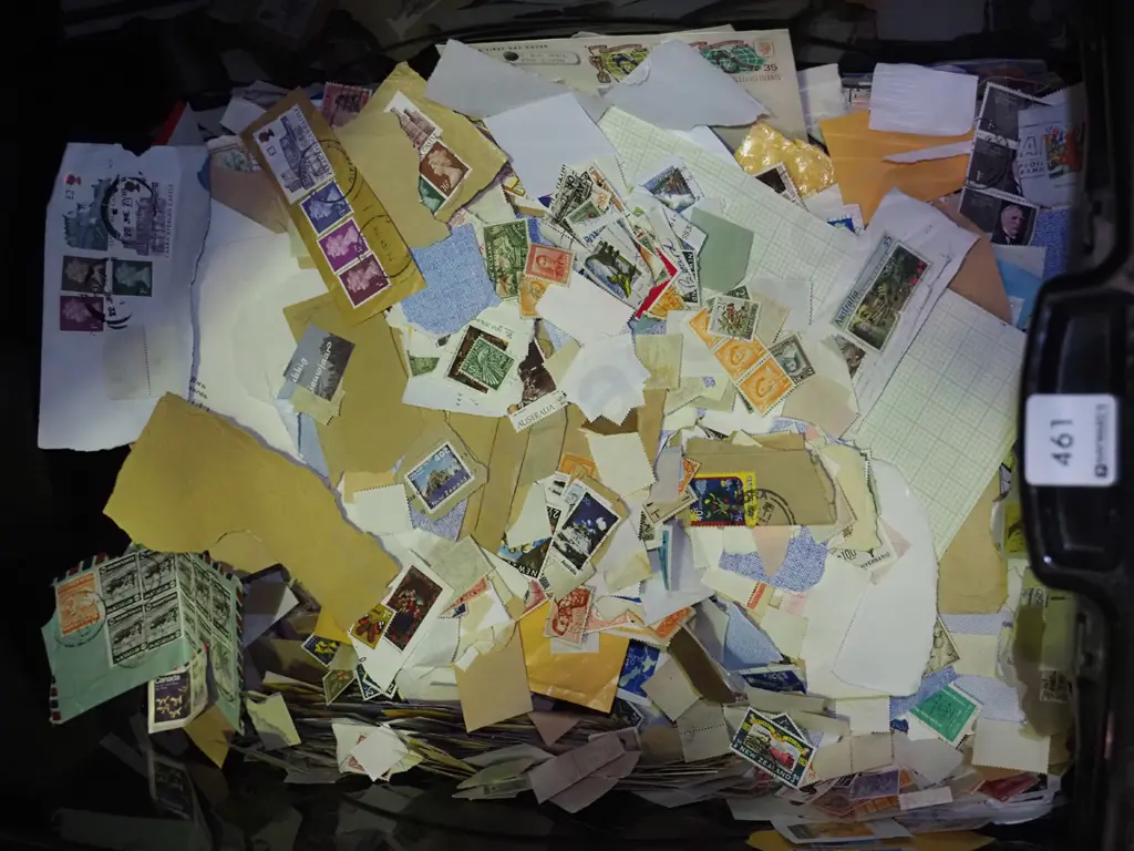 black plastic container quarter filled with loose stamps Image 1++