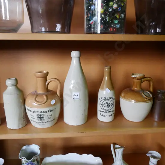 shelf of stoneware bottles (damage to some bottles)
