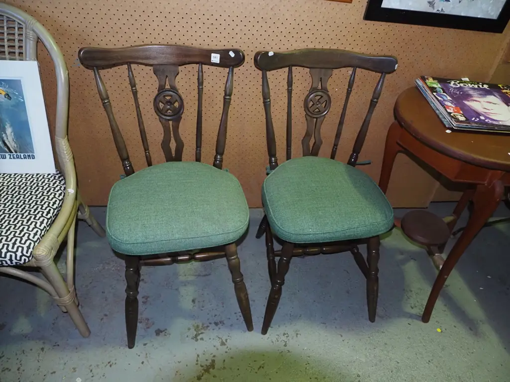 pair of splat back wooden dining chairs with green cushions Image 1++