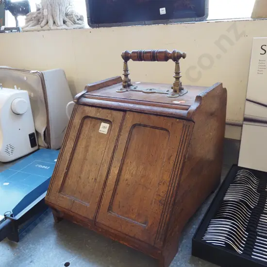 vintage oak coal scuttle with brass door-opening mechanism connected to brass and timber top handle, with tin liner.