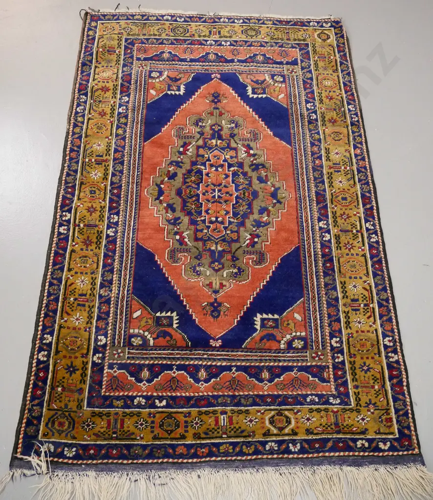 Persian style hand knotted wool floor rug - multi coloured on dark blue and red ground. Fringe mostly gone from one end. Image 1++