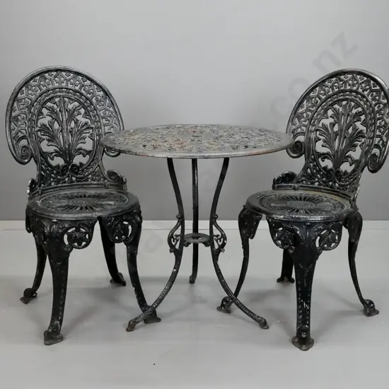 heavy cast metal black painted round outdoor 3-legged table with umbrella hole and 2 chairs - damage on edge of table,