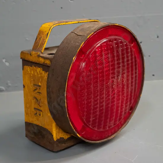steel railway signal lamp marked NZR on side, with large red lens marked Stratolite - wear and tear, paint loss and