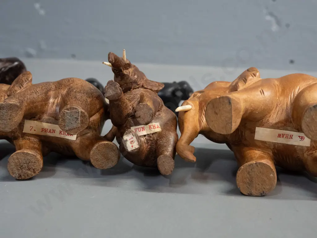 7 small carved teak, ebony and other hardwood elephants - one missing one tusk. Largest is H-95 L-110 Image 1++
