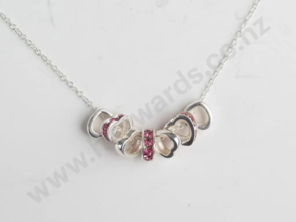 silver necklace with 7 small hearts 3 with pink stones stamped 925 Image 1++