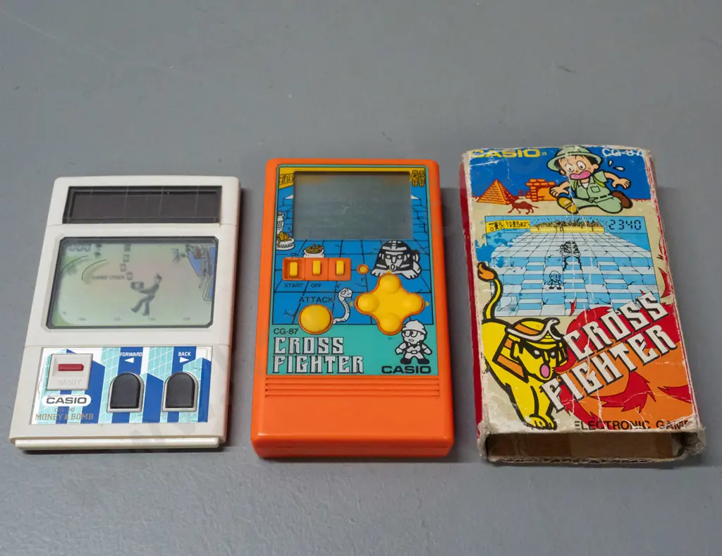 2 1980s Casio miniature game consoles - Cross Fighter with original box and "Money & Bomb" - box is very worn - untested Image 1++