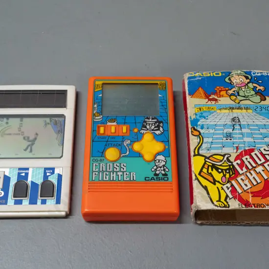 2 1980s Casio miniature game consoles - Cross Fighter with original box and "Money & Bomb" - box is very worn - untested