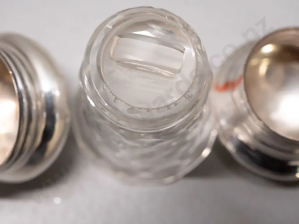 2 cut glass scent bottles with sterling silver tops - smaller one has glass stopper under cap, both caps have some dents Image 1++
