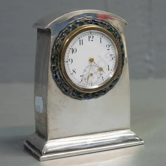 small mantel clock in sterling silver case, enamel band around bezel, brass bezel and porcelain face marked Swiss made
