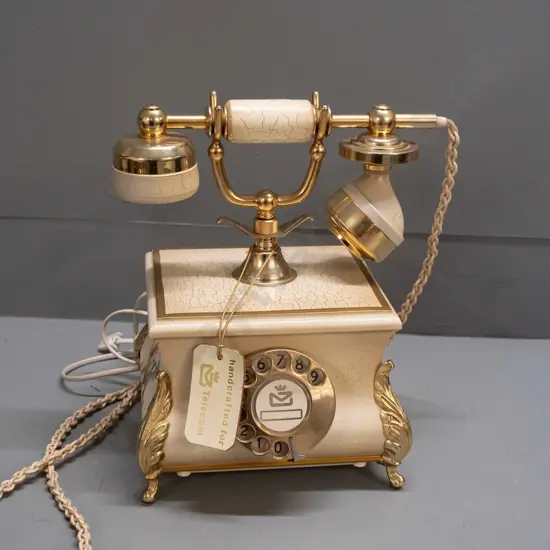 retro 1980s rotary dial telephone with brass finish metal, crackle-finish timber and floral transfers, cast metal feet -