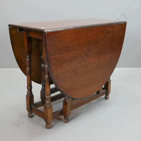 vintage oak oval gate-leg drop side table with turned legs and supports, square section stretcher base. Some stain marks