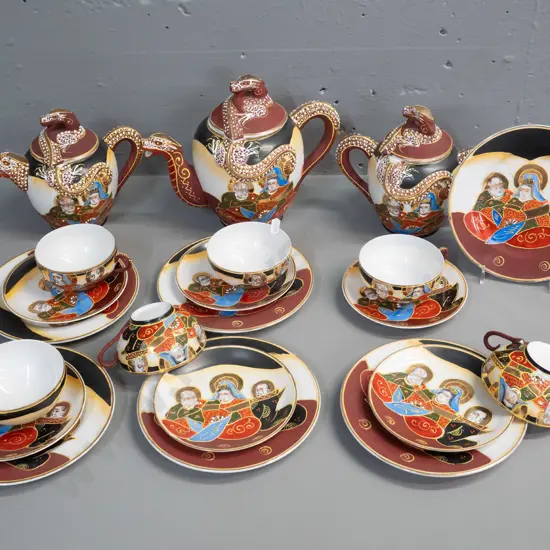 Japanese tea set with figural portrait and raised dragon motif decoration and lithophane geisha face in tea-cup base.