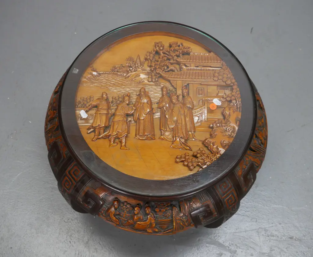 vintage Chinese round table with carved top and sides on 4 sweeping carved legs, glass top over carved scholar scene. Image 1++