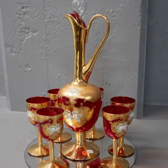 red Venetian glass stoppered handled decanter and 6 small goblets - Vetro Opalina Italy label - on round display mirror.