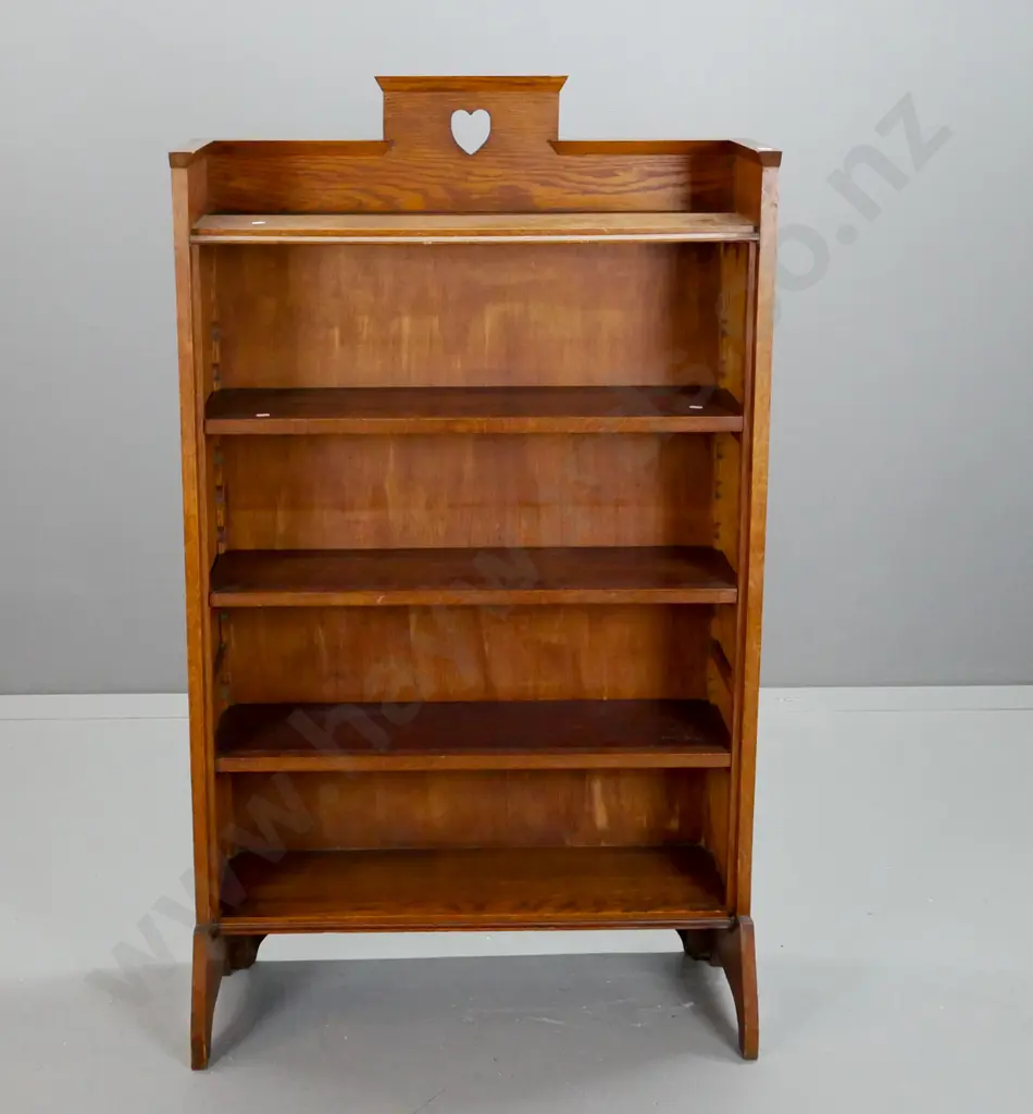 oak arts & crafts style bookcase with 3 adjustable shelves, pierced heart motif cutout at top - some fading to one side Image 1++